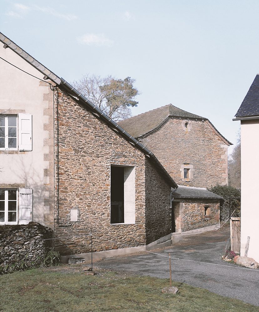 Ouverture contemporaine en béton dans un mur en pierre