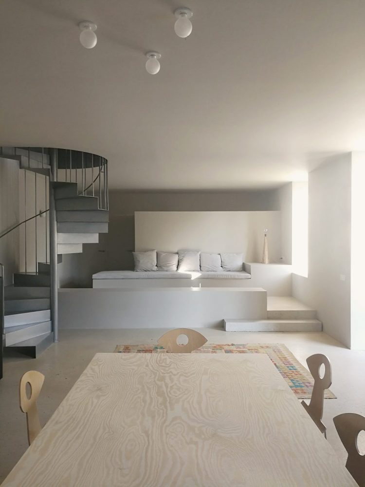 Cuisine et salle à manger avec canapé sur mesure et escalier en acier