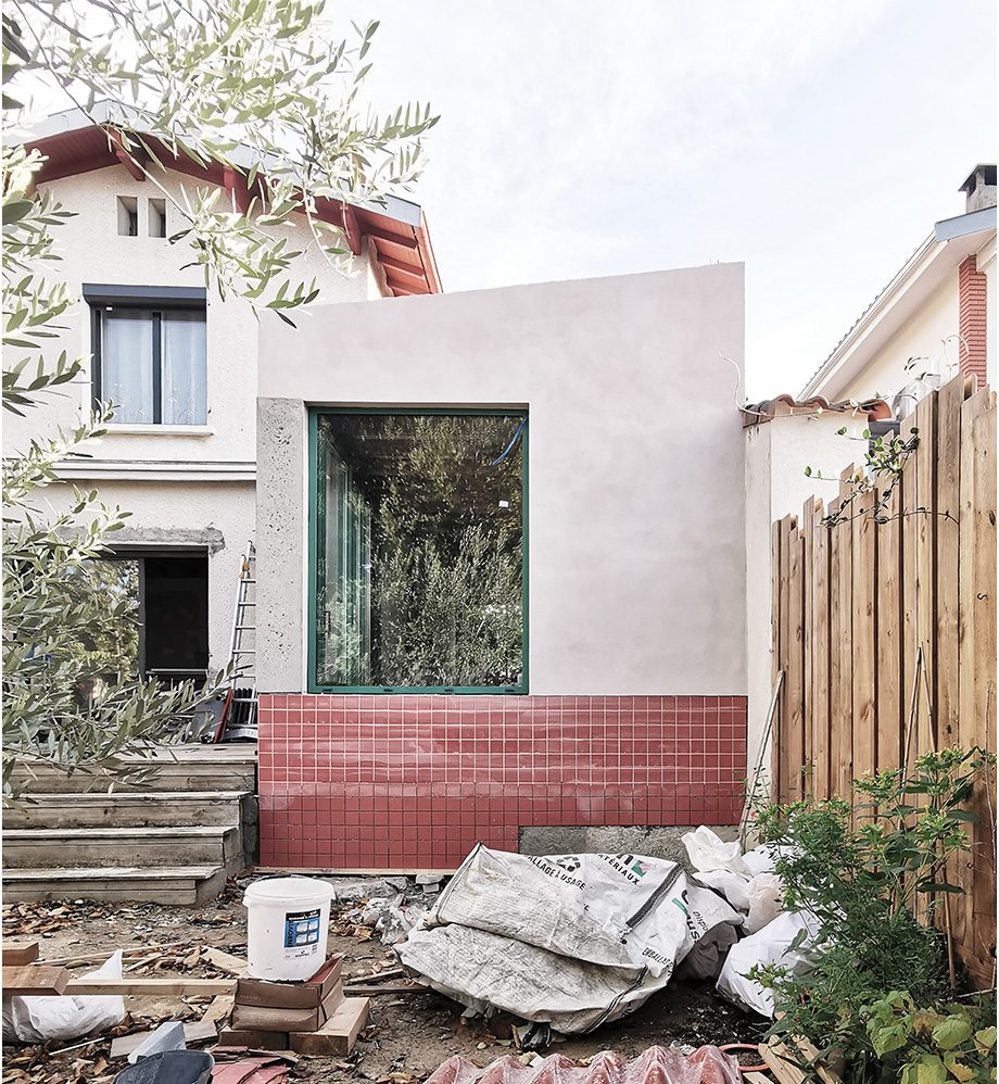 Extension de une maison avec menuiseries vertes et de la faïence en façade